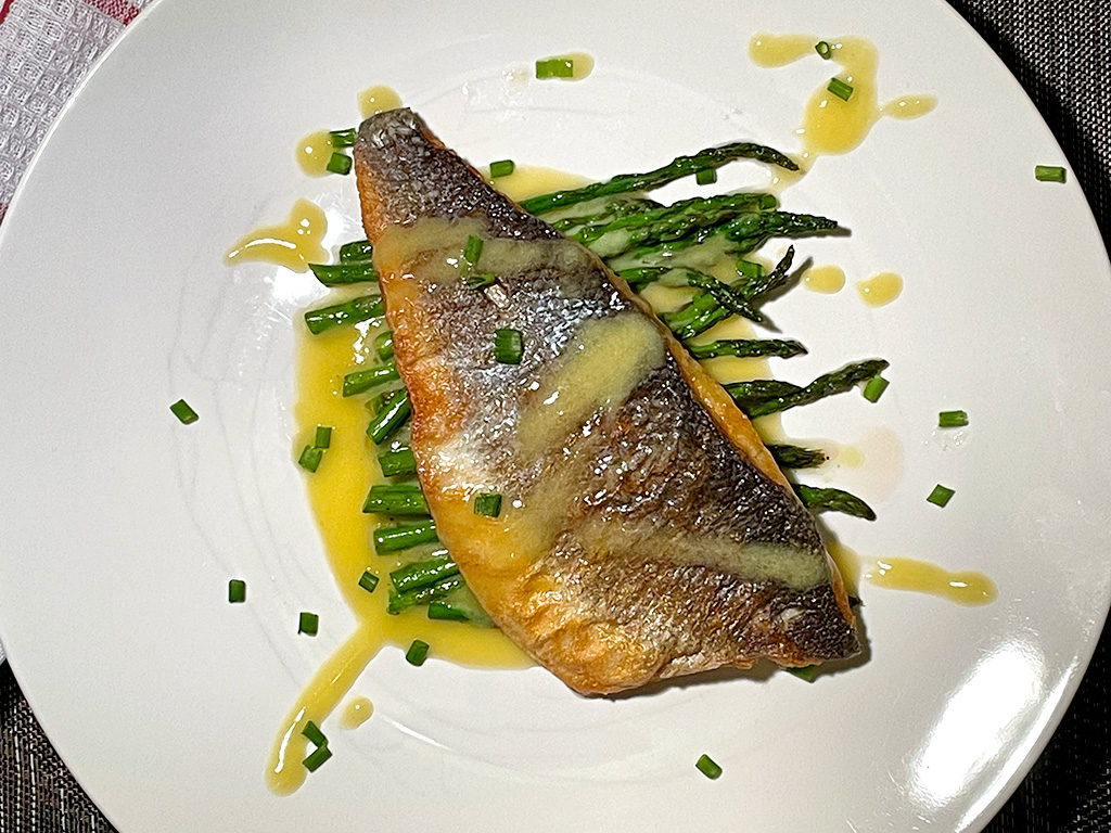 sea bass with beurre blanc on a bed of asparagus