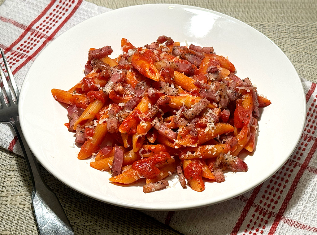 A plate of bacon tomato pasta from above