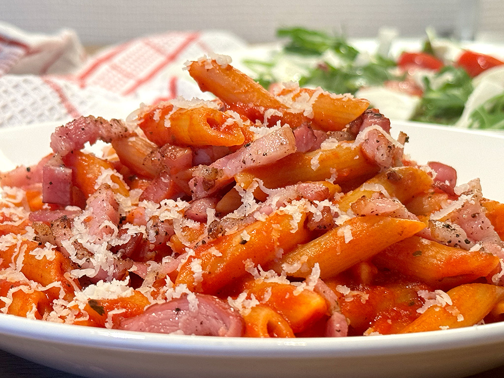 Bacon tomato pasta with salad in the background
