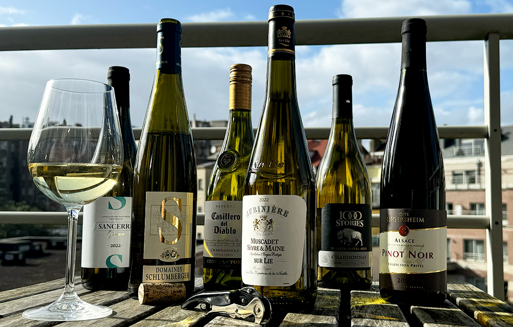 different wine bottles on a table in the sun