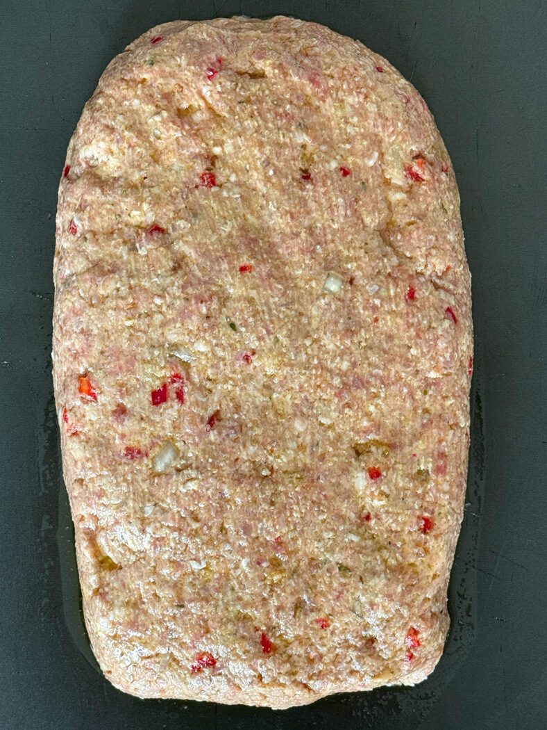 Raw meatloaf on a baking tray